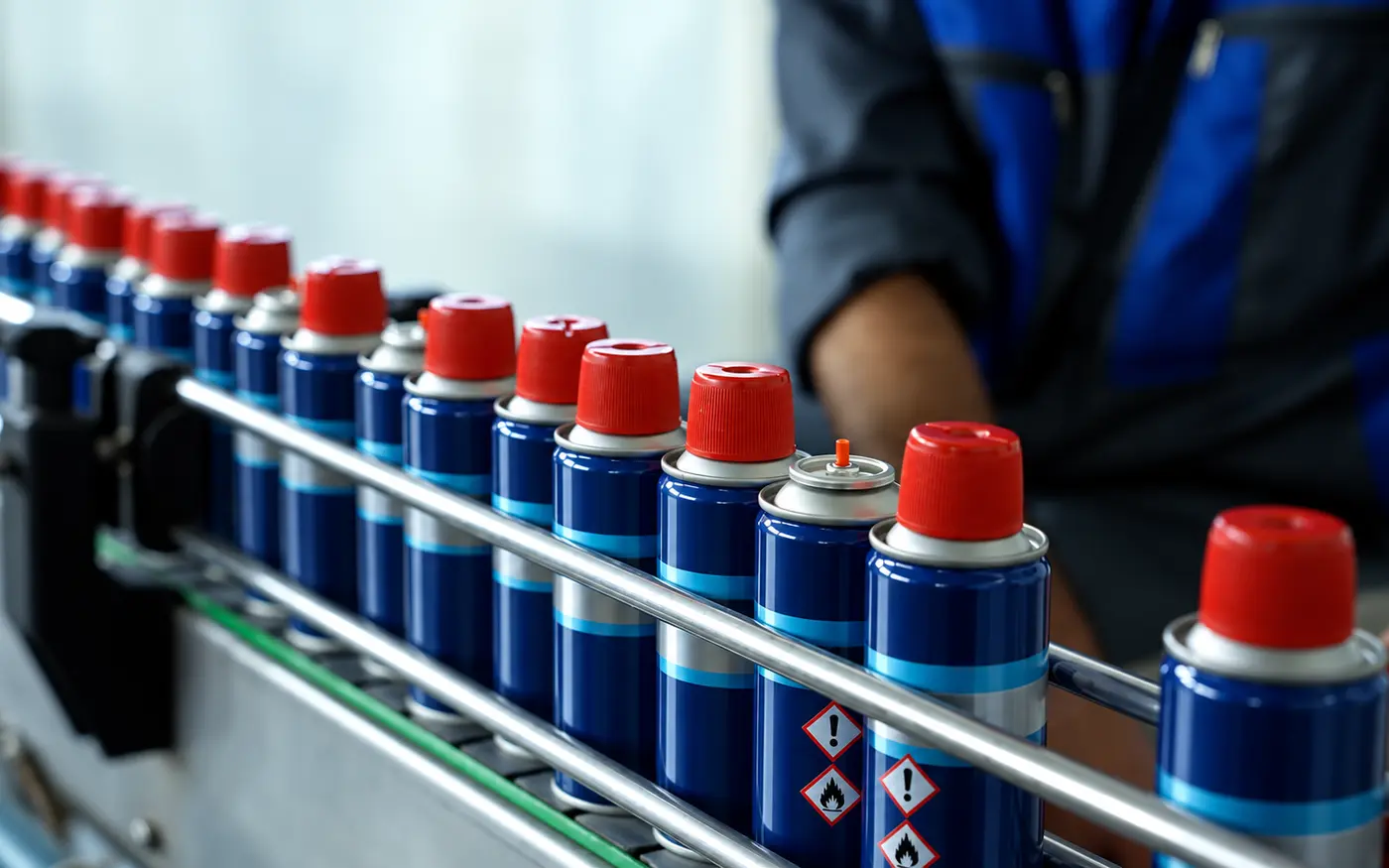 Aerosol cans moving through the DENIZ production finishing line